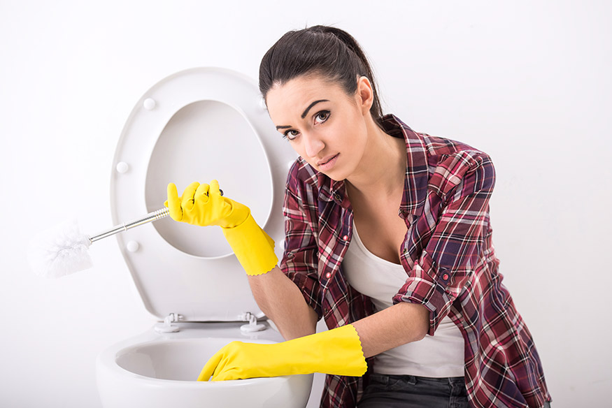 woman cleaning toilet bowl stains