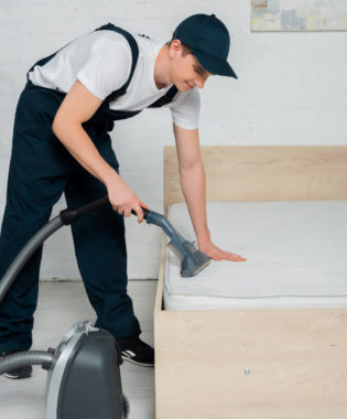 man vacuuming bed to get rid of bugs and eggs