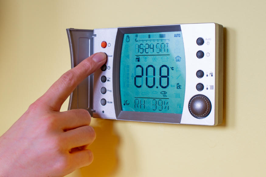 Closeup of a woman's hand setting the room temperature on a mode