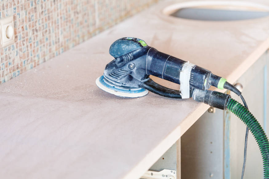 sanding a kitchen bench for waterproofing cabinets