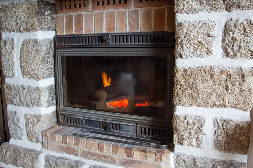 fireplace insert surrounded by bricks