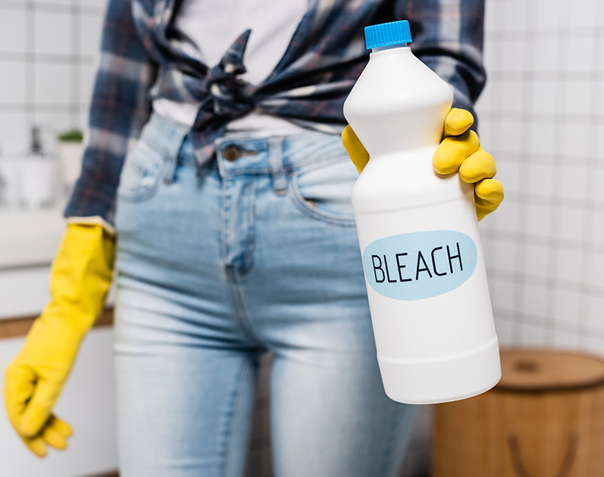 woman holding a bottle of bleach