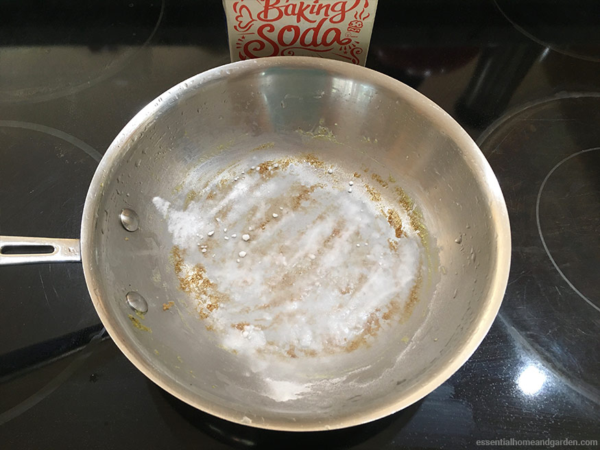 Baking soda being used to clean stainless steel pan