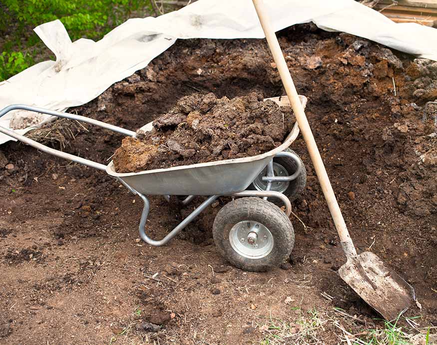 a wheelbarrow filled with manure compost