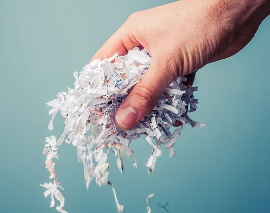 A hand holding shredded paper