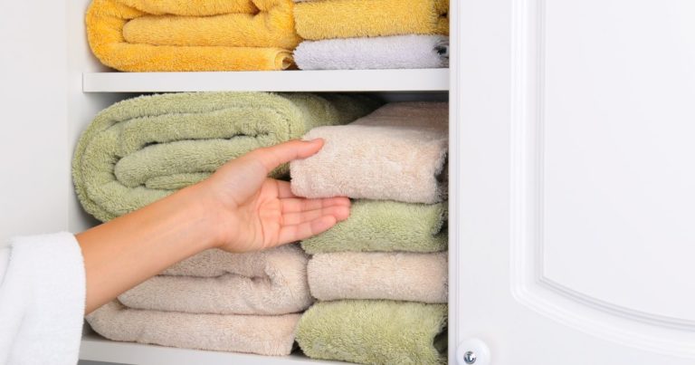 a person taking towel from the storage