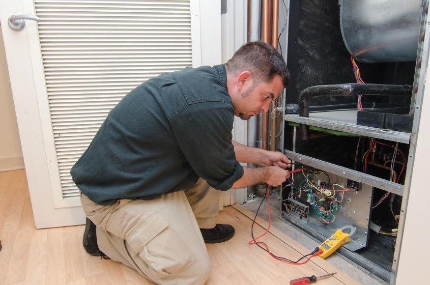 Professional HVAC repairman inspecting the HVAC unit