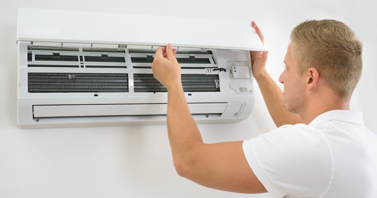 a man inspecting an air conditioner