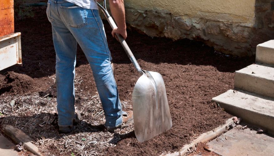 A person shoveling and adding compost to anaerobic soil