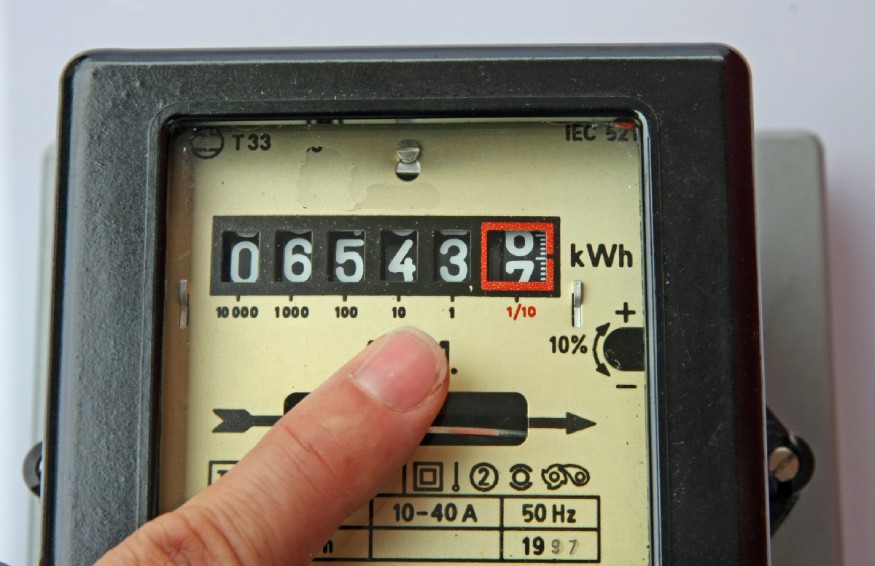 a person pointing the electric meter box