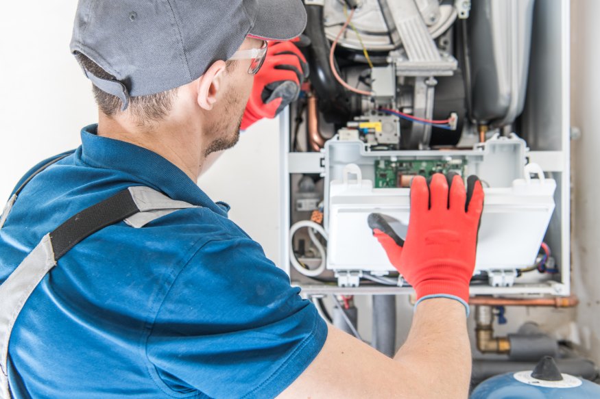 A plumber working on a hot water heater.