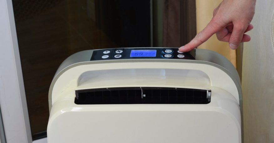 a person pressing the button of a dehumidifier