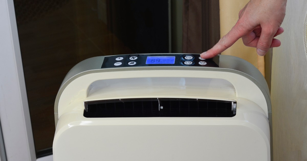 a person pressing the button of a dehumidifier