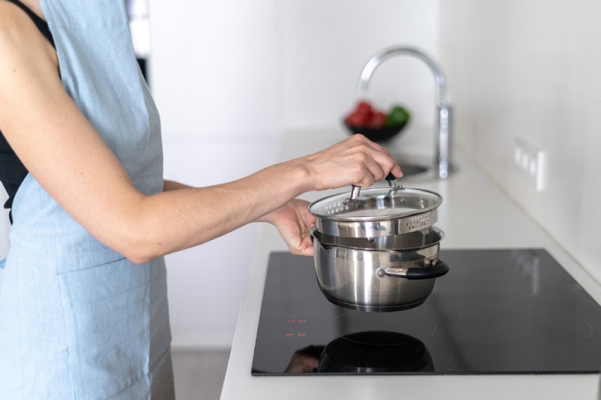 woman putting a pan on the induction stove
