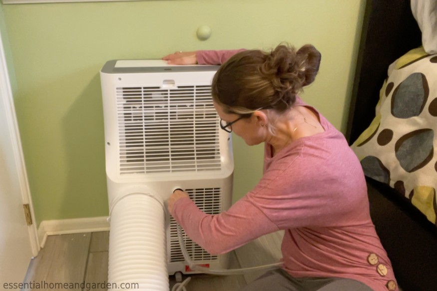 a woman installing the continuous drain for a portable ac