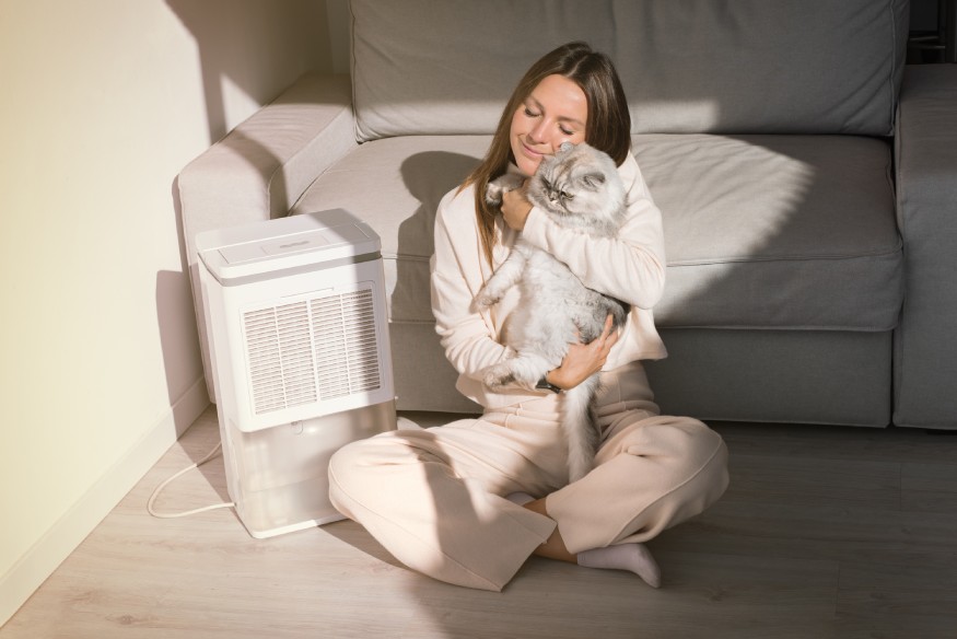 woman sitting next to a quiet dehumidifier