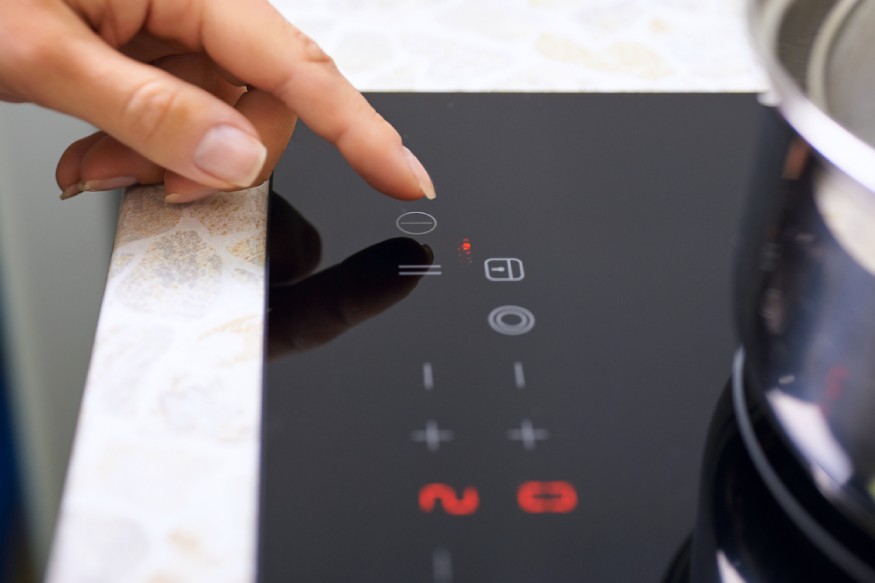 woman unlocking the lock button of the induction cooktop