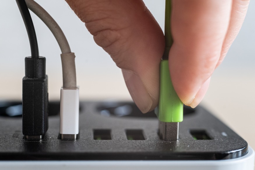 a person plugging a USB cable to an extension