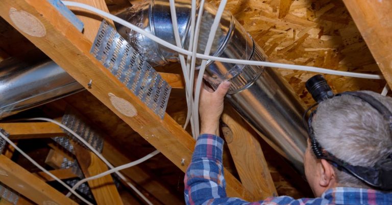 A HVAC expert installing ductwork