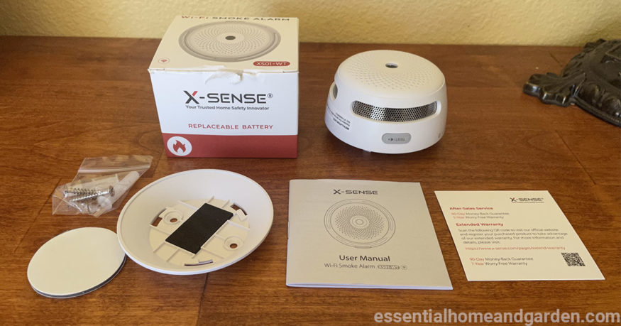 X-Sense XS01-WT Wi-Fi Smoke Detector and its accessories on the table