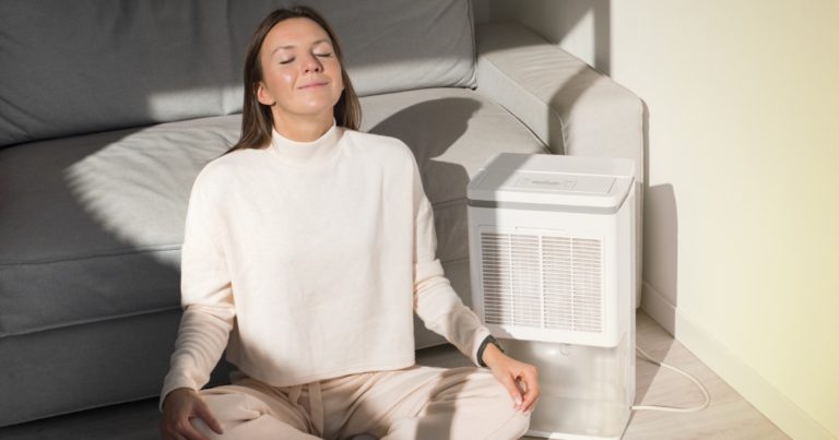 person sitting next to a dehumidifier