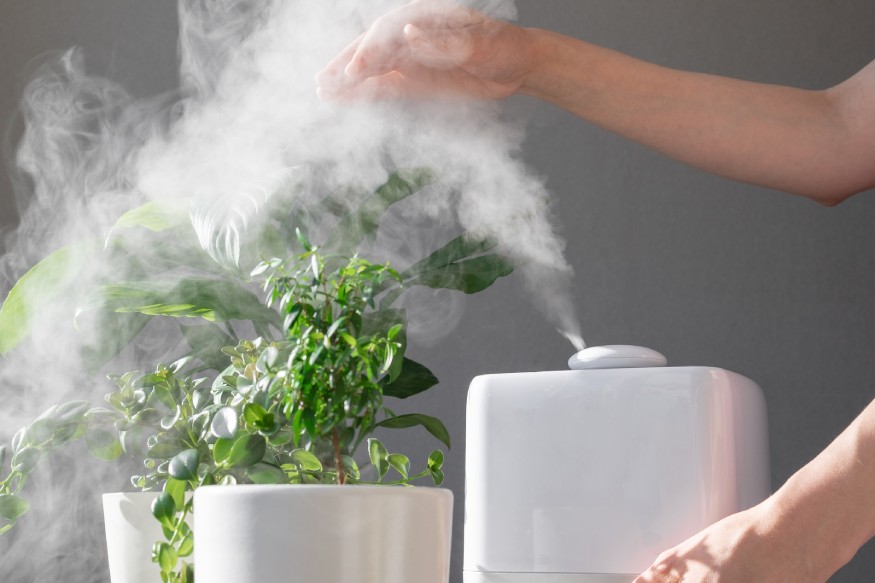 a person adjusting the mist level of a humidifier