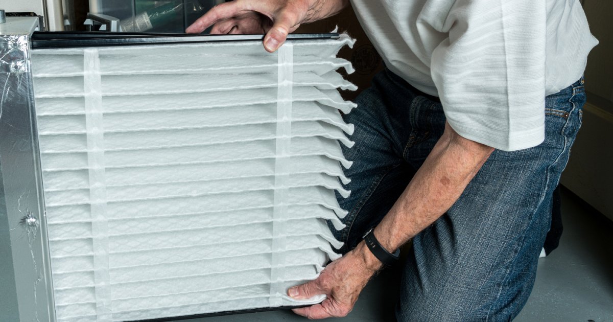 a person inserting a new HVAC air filter