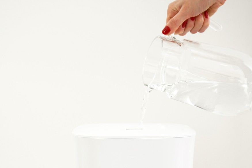 woman adding distilled water to a humidifier
