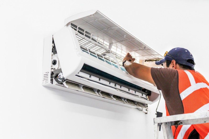 a technician checking an AC’s low air flow issue