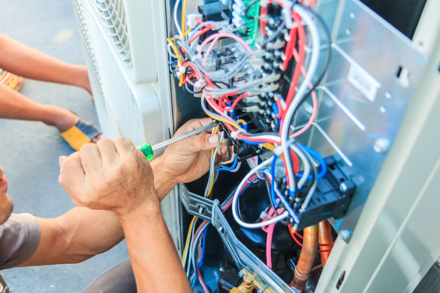 technician checking the electrical wiring of an HVAC