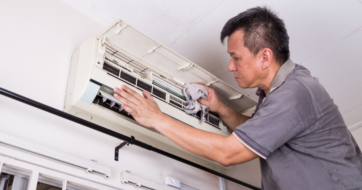 a technician inspecting an air conditioning unit