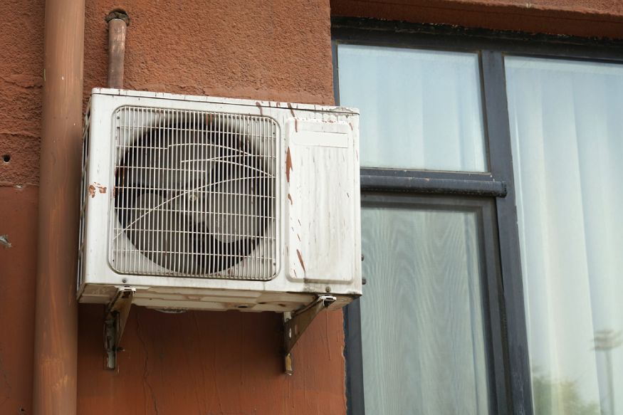 an old and rusty outdoor unit of an ac