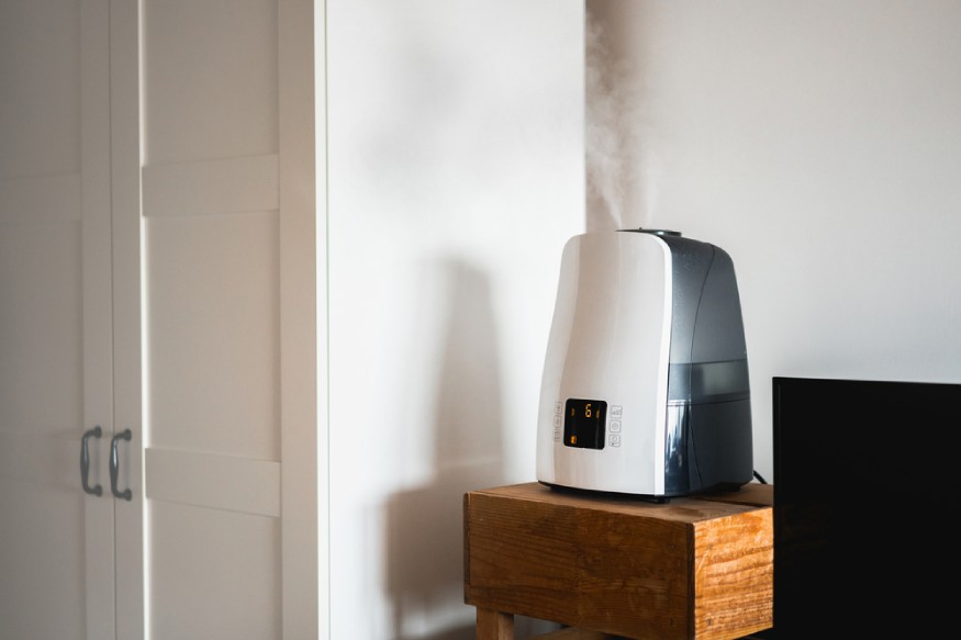 a humidifier releasing mist in the bedroom