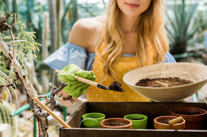 woman adding homemade potting mix to containers