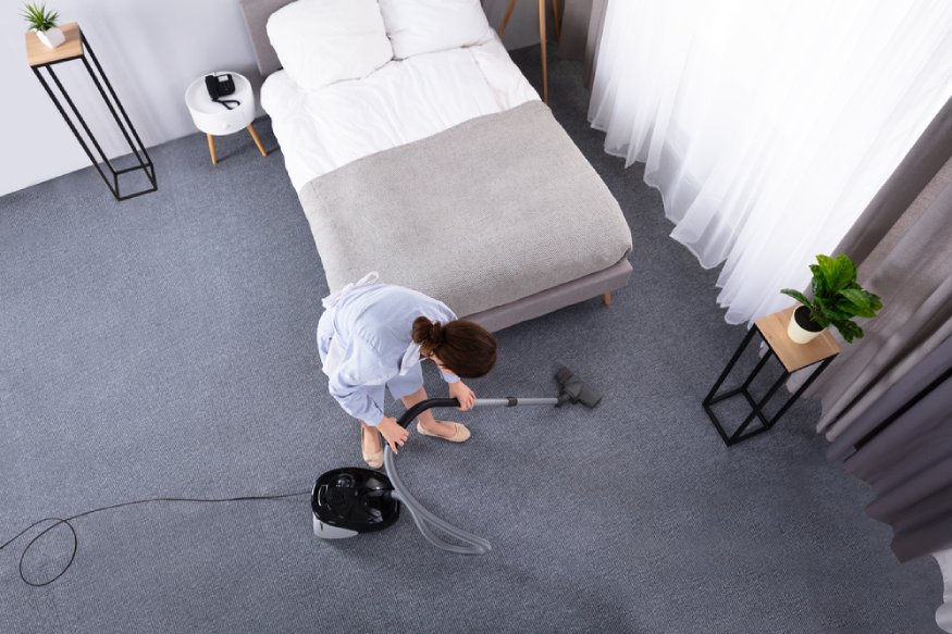 woman cleaning the bedroom