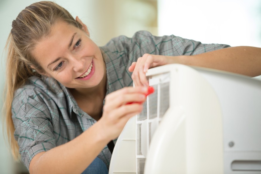 woman removing the filter of a portable AC