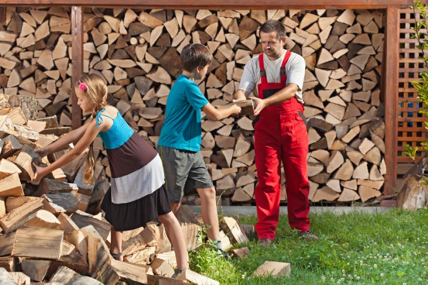 family stacking chopped wood for drying