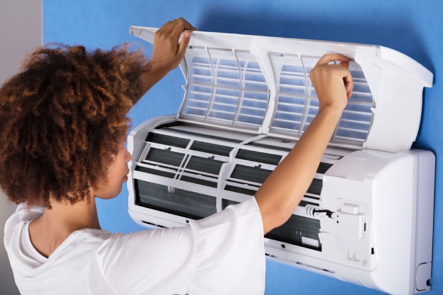 woman checking the ductless AC unit’s washable filters