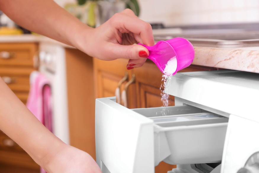 woman adding laundry detergent powder