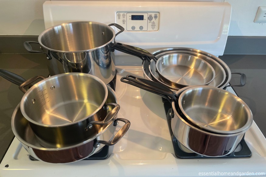 complete Legend copper core cookware set with no lids on a gas stove