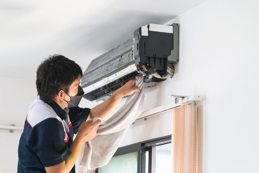 HVAC technician cleaning a mini split AC