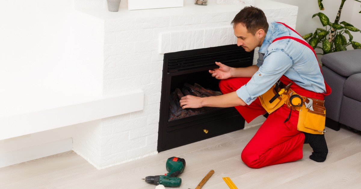a technician converting a wood fireplace to electric