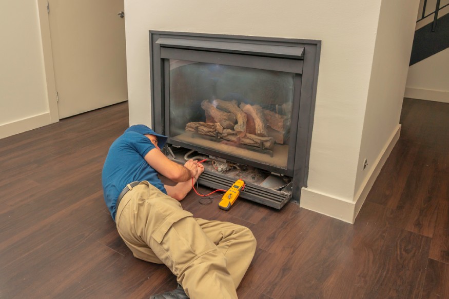 a technician servicing a gas fireplace