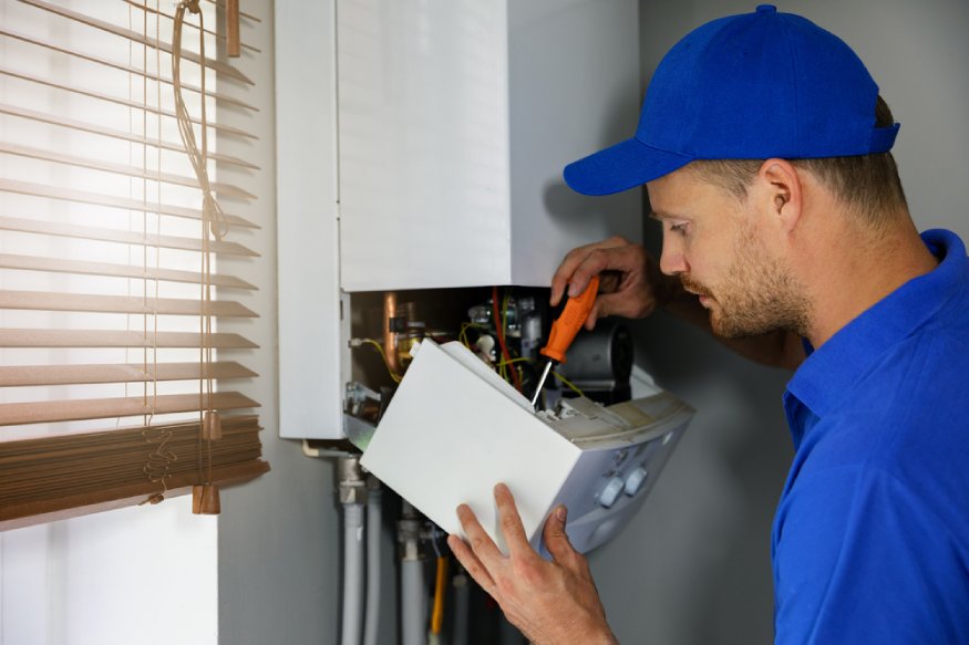 HVAC technician servicing a central heating system