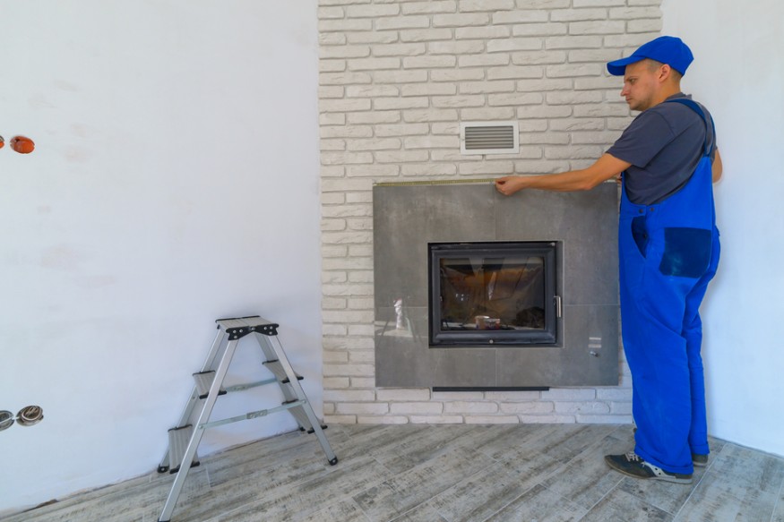 a technician measuring the fireplace