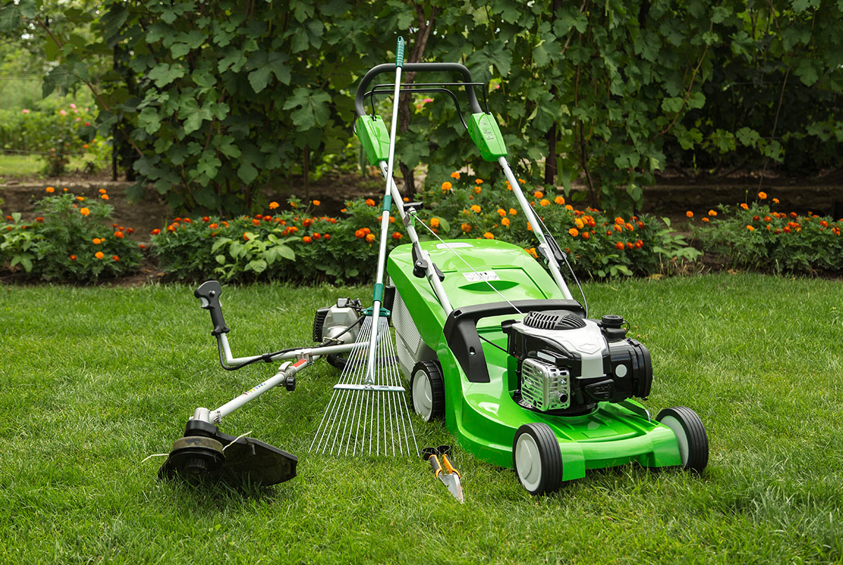 Lawn tools and equipment, A green lawn mower with a rake and a brush cutter