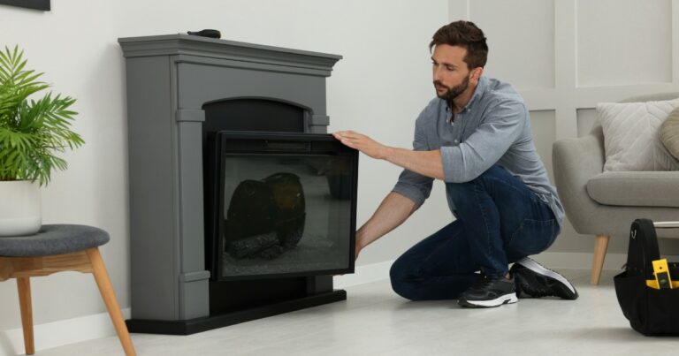 man installing an electric fireplace insert
