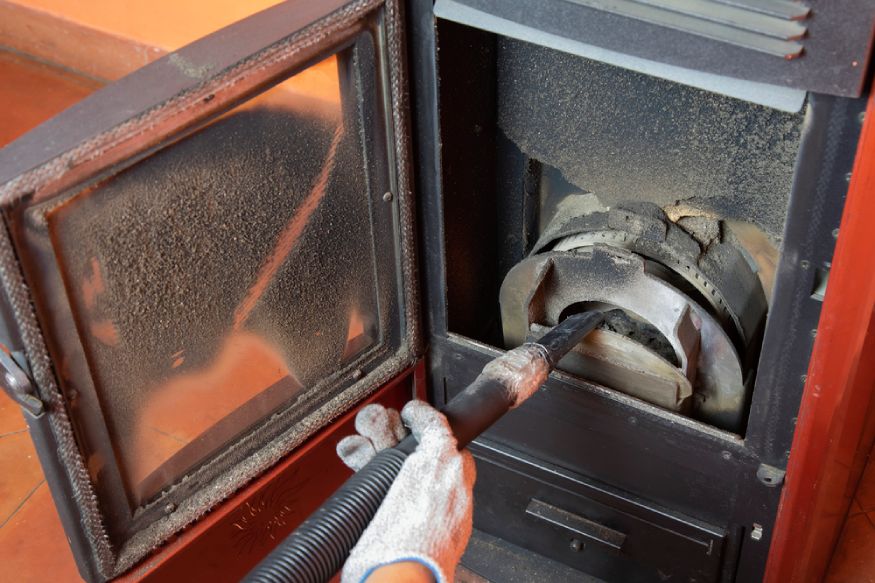 man cleaning a pellet stove