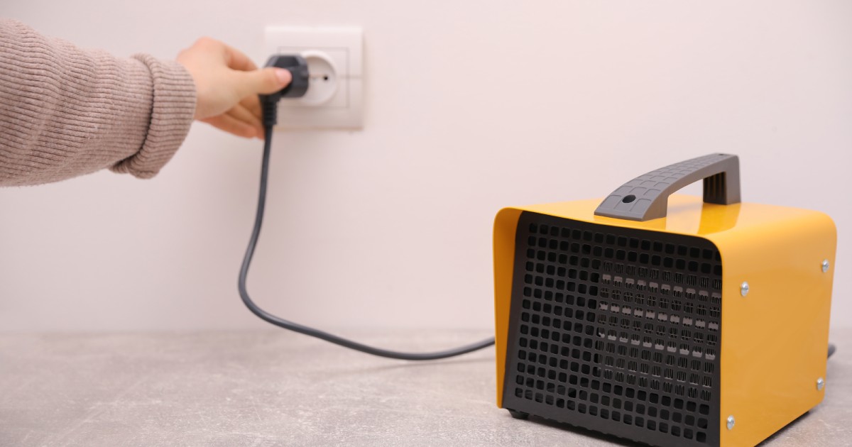 woman plugging a heater with a ptc element