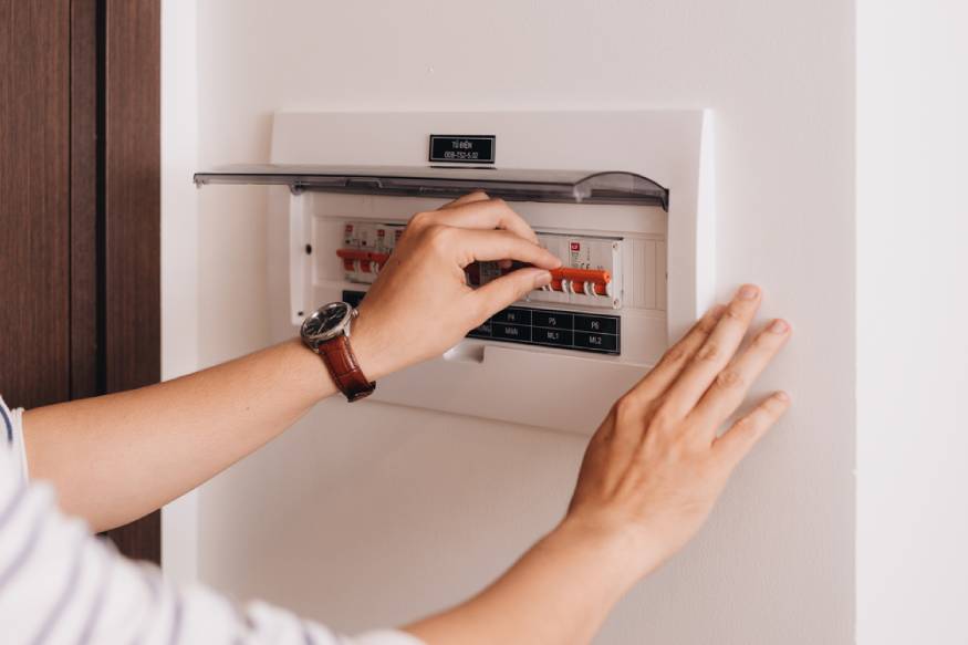 homeowner turning on the AC circuit breaker